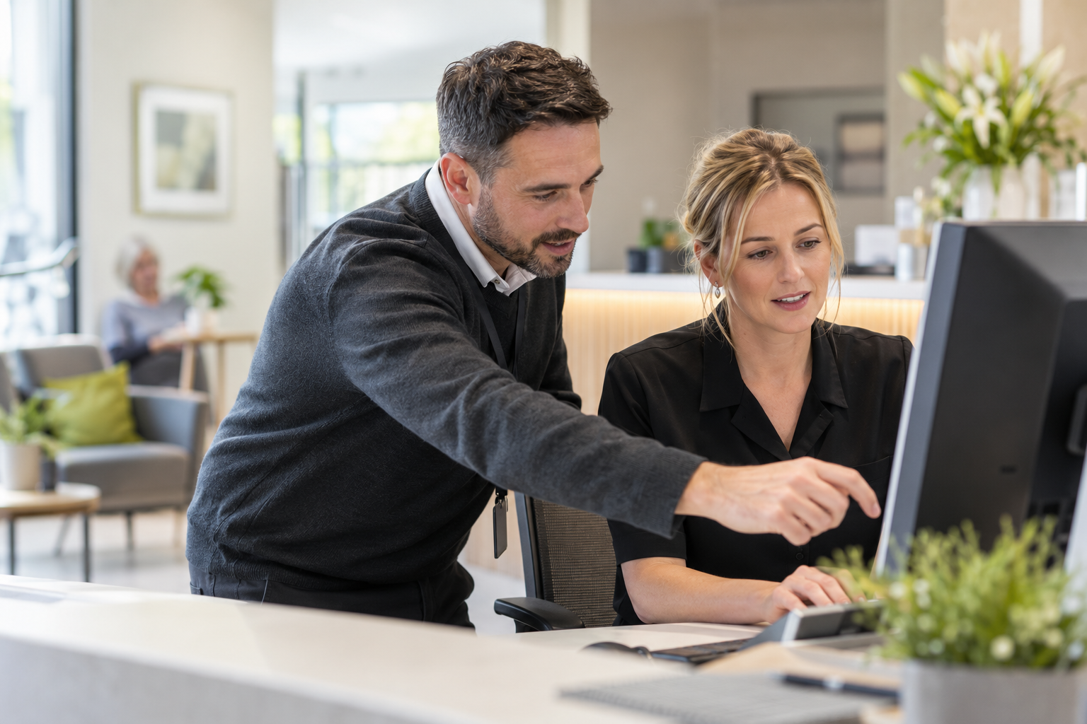 Illustrative scene of an IT adviser working through a computer setup with a practice manager